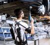 Audi-Mitarbeiter in der Montage erproben die Exoskelette beispielsweise beim Verschrauben der Unterbodenverkleidung.