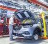 Ein Mitarbeiter im Opel Werk Eisenach steht vor einer geöffneten Motorhaube.
