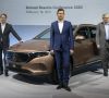 Die Daimler-Vorstände Ola Källenius, Harald Wilhelm und Martin Daum stehen bei der Bilanz-Pressekonferenz vor einem neuen EQA-Modell