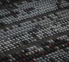 Luftaufnahme von einem Parkplatz voller Neufahrzeuge.