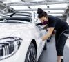 Eine Mitarbeiterin von Daimler überprüft in der Factory 56 den Lack einer S-Klasse.