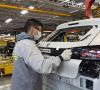 Ein Peugeot-Mitarbeiter im argentinischen Werk El Palomar bringt eine Heckapplikation auf.