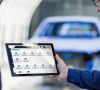 Zwei Mitarbeiter von SAIC Volkswagen bedienen eine Applikation von Dürr auf dem Tablet in der chinesischen Lackiererei.