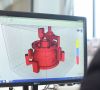 Ein Mitarbeiter von Voxeljet fertigt ein Antriebsteil am Monitor und bereitet es damit für den 3D-Druck vor.