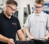 Zwei Bosch-Mitarbeiter begutachten eine 48-Volt-Batterie